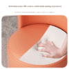 Orange modern curved upholstered chair detail (hand demonstrating fabric texture) - Comfort & material reference for home accent seating