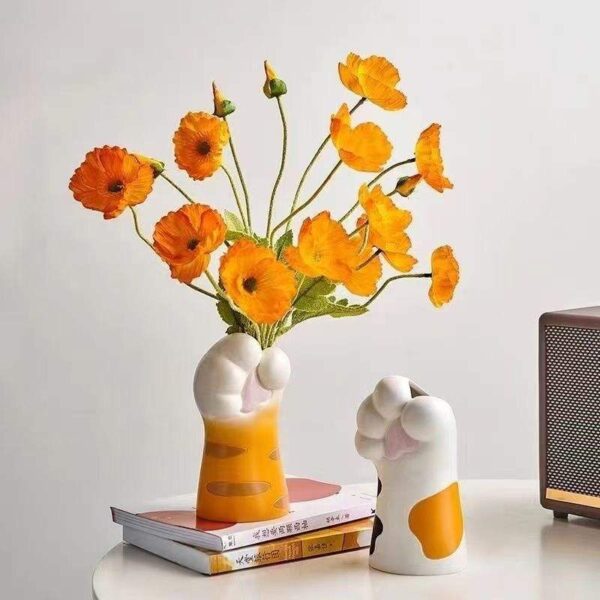Tabletop Decor Scene With Yellow Flower Vase, Stacked Books & White Stylized Ornaments Title