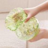 Hands Holding Green Flower-Shaped Glass Decorative Ornament