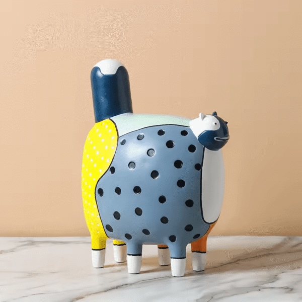 An ins-style decorative ornament featuring a pop-art patchwork cartoon cat with a rotund body, six legs, a navy-and-white tail, and a relaxed expression. The resin piece blends yellow polka-dot, grey polka-dot, white, navy, and orange sections, adding a playful, vibrant charm to kids' rooms, desks, or modern living spaces.