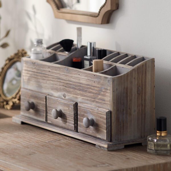 Side angle view of the rustic wooden makeup organizer, showing its depth and sturdy construction. It is styled on a wooden dresser with a vintage mirror and perfume bottle.