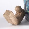 A wabi-sabi style abstract decorative ornament with a natural travertine texture, featuring a V-shaped base and a matching sphere. Displayed alongside a Van Gogh art book, it adds a serene, artistic focal point to modern home decor.