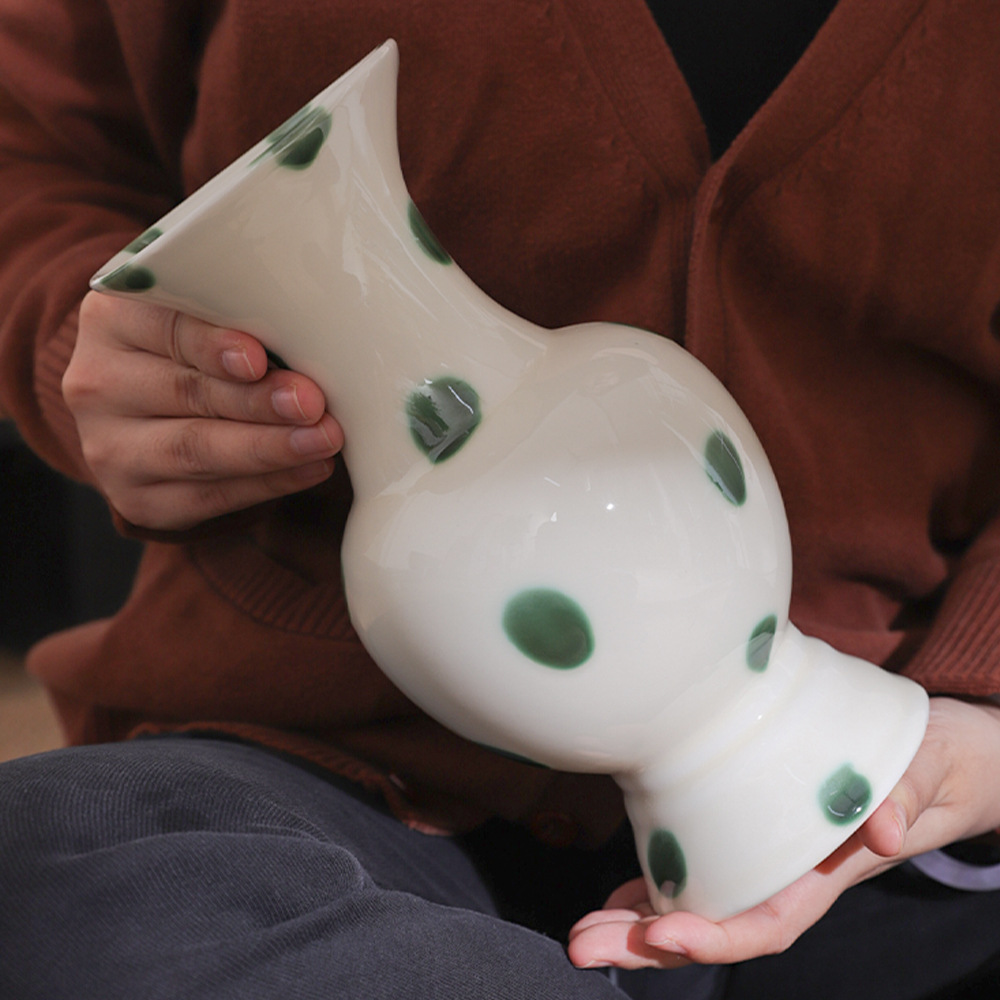 Chinese-style green dot ceramic vase held in hand