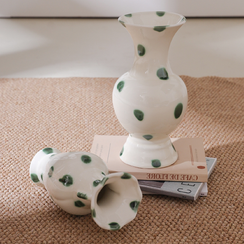 Green dot ceramic vase styled on a woven tabletop