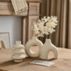 Bohemian matte bisque ceramic vase set of 3 with arch, donut and ribbed shapes styled on a wooden table