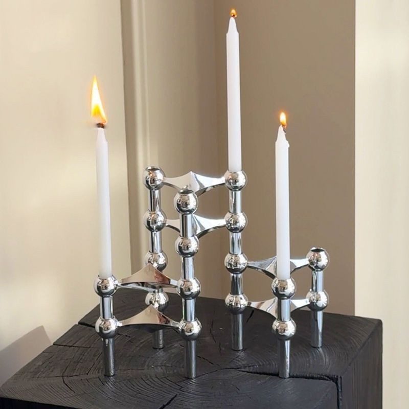 Lit tablescape — chrome units with taper candles