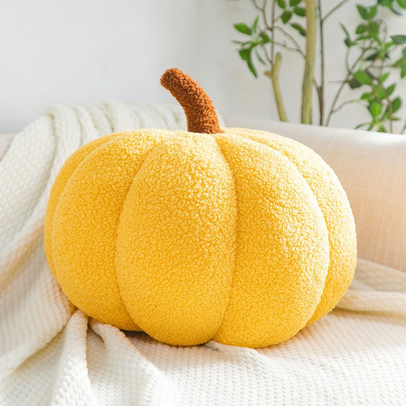 Sunny yellow pumpkin pillow styled on a boucle throw — the signature colourway