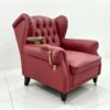Burgundy tufted armchair with brass swing-arm rotating tray table mounted on the armrest, side view